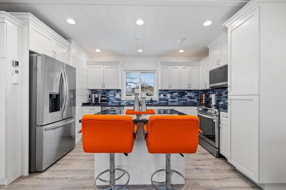 Beautiful modern kitchen with island seating and stainless steel appliances.