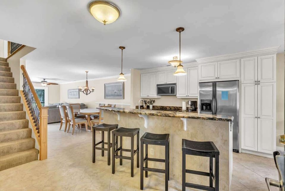 Open kitchen with granite countertops and seating for four at the breakfast bar
