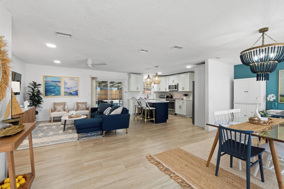 Relax in your beautifully designed open-concept living space featuring coastal-inspired décor, modern kitchen, and comfortable seating perfect for memorable gatherings.