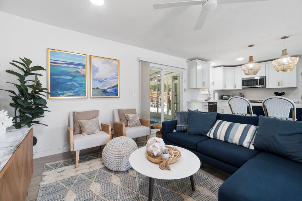 Sink into plush seating in your bright open-plan space, where coastal artwork and modern comfort create the perfect retreat for relaxation.