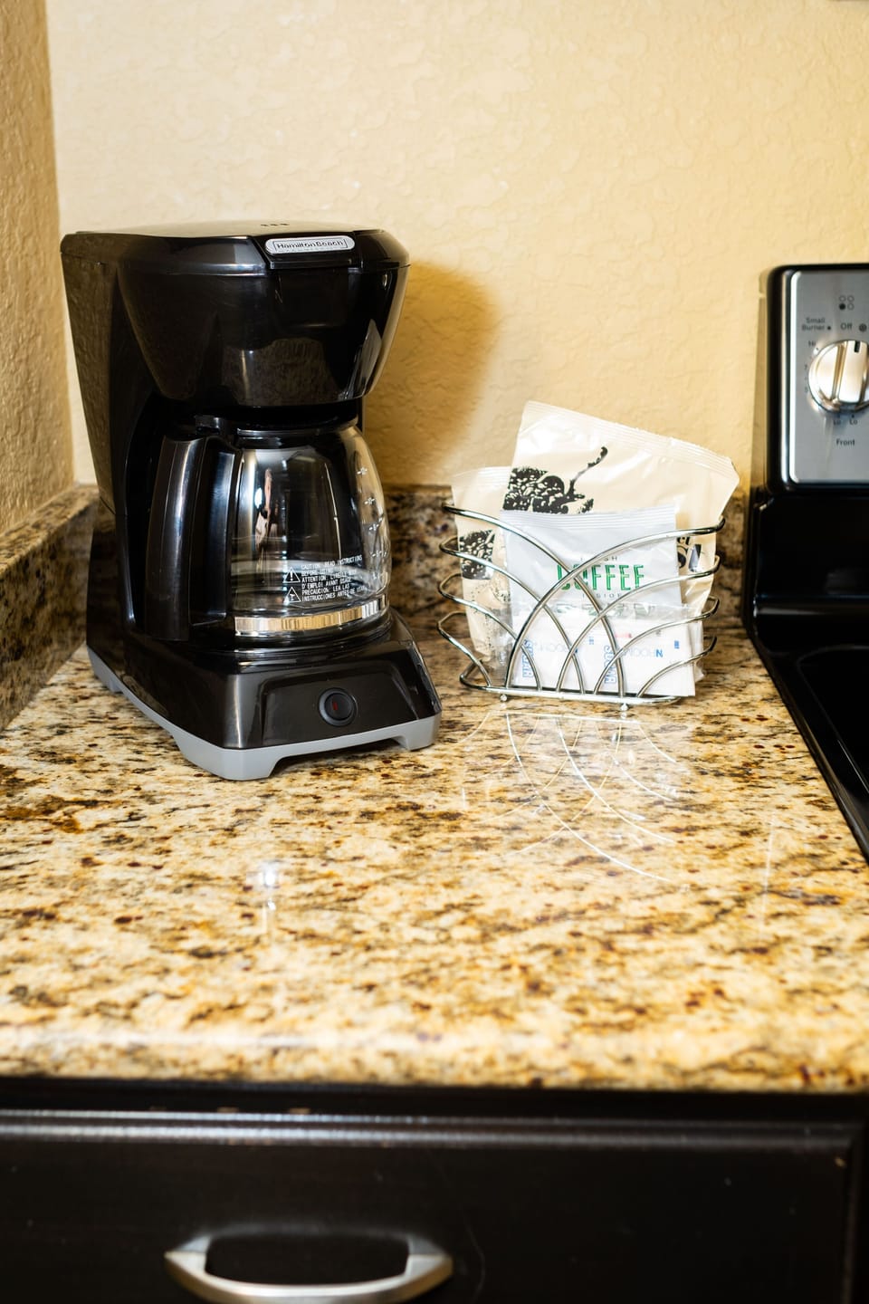 A fully equipped kitchen features a coffee maker and stylish granite countertops, providing convenience for all your cooking needs.