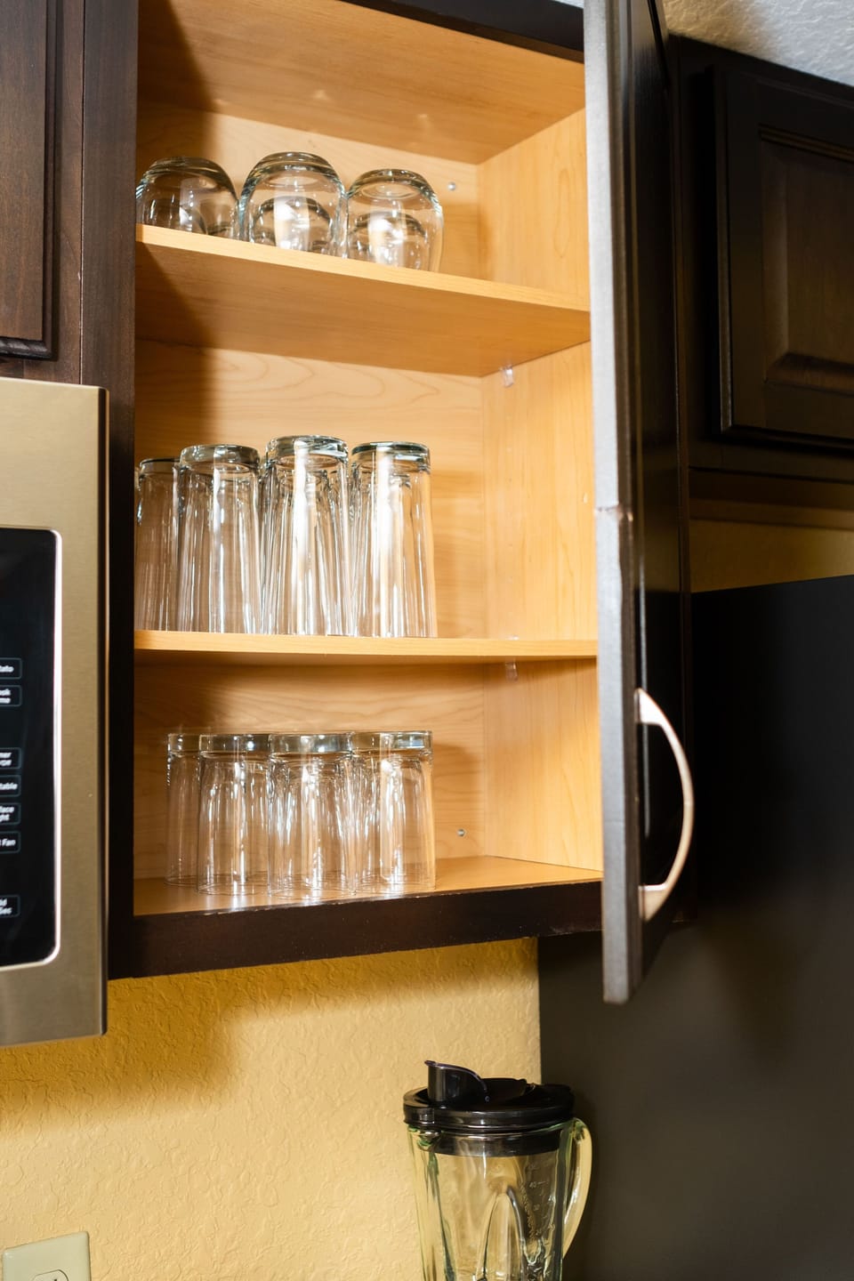 The well-organized cabinet showcases an assortment of elegant glassware, making it easy to enjoy drinks with family and friends during your stay at the villa.