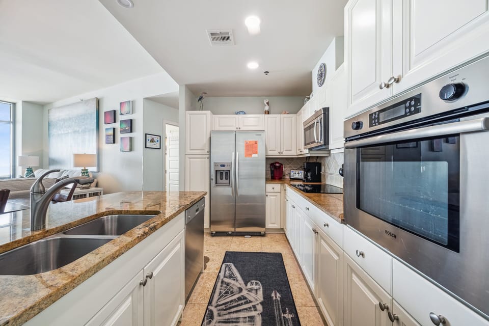 Spacious kitchen with granite countertops, stainless steel appliances, and custom cabinetry—ideal for coastal cooking and entertaining at Palisade Palms.