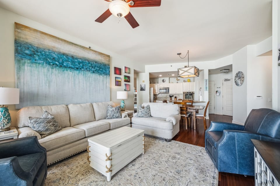 Spacious open-concept living and dining area at Palisade Palms featuring stylish coastal decor, hardwood floors, and a modern kitchen.