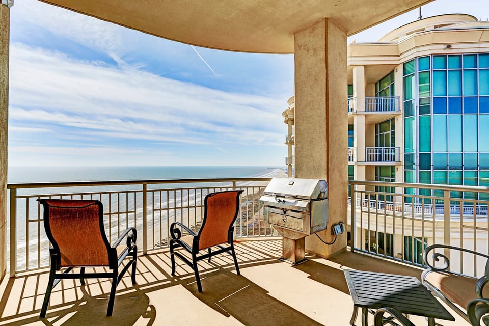 Private beachfront balcony with grill and lounge seating—perfect for relaxing or dining with Gulf views.