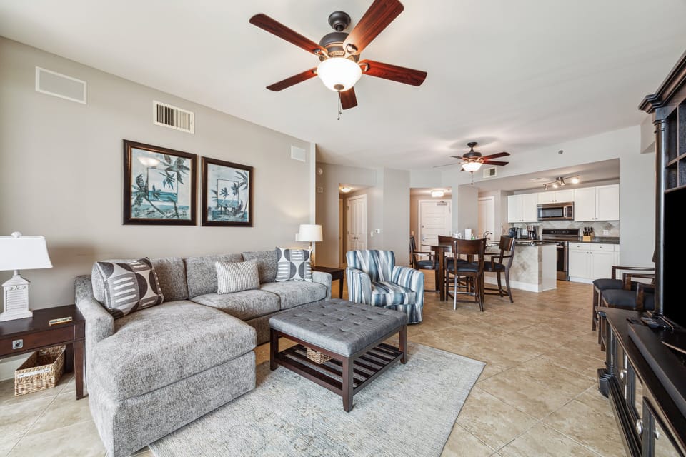 Open-concept living and dining area features tile flooring, coastal decor, and direct access to a private balcony with stunning Gulf views—perfect for relaxing or entertaining.