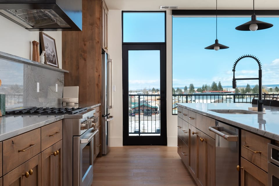 Chef’s kitchen with premium appliances and mountain-view balcony access