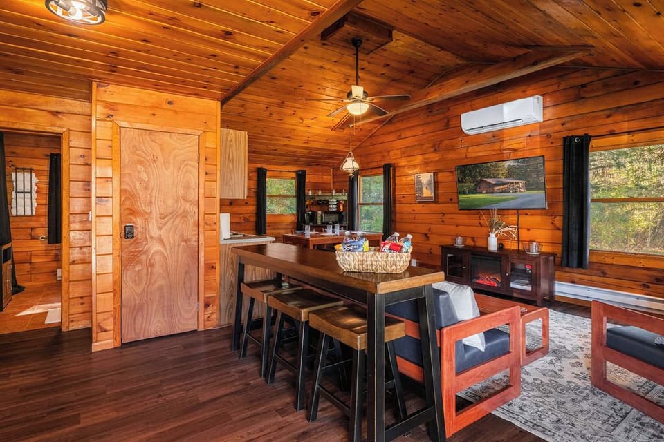Bright and open living space with vaulted ceilings, large windows, and a cozy setup for movie nights or rainy day lounging.