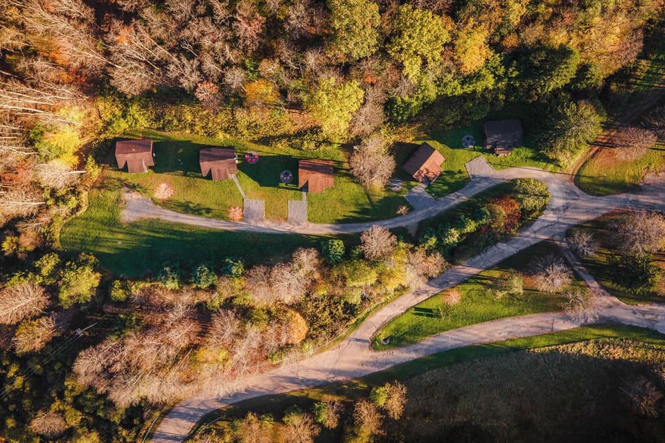 A quiet row of rustic cabins tucked into the forest—DentonGo Cabin #2 sits trailside, ready for your next adventure.