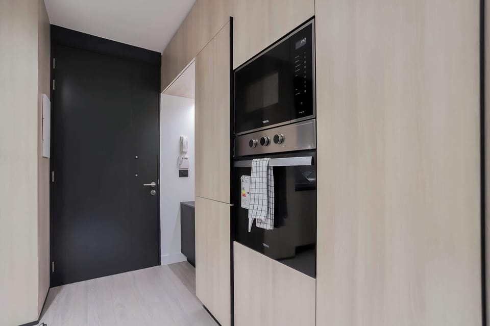 Sleek and modern kitchen with built-in appliances and stylish cabinetry, perfect for culinary enthusiasts.