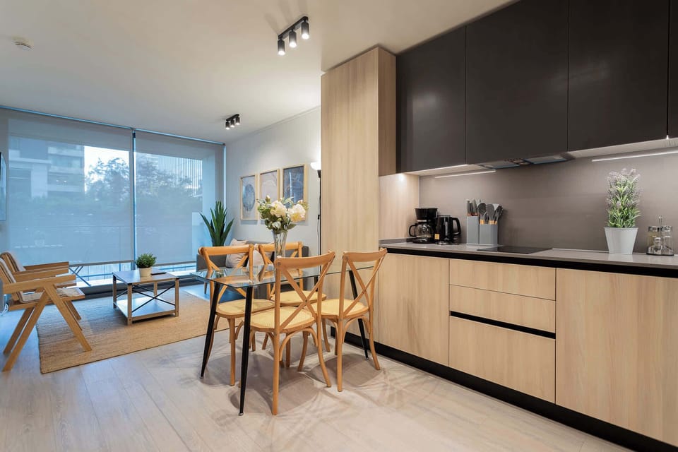 Experience modern comfort in this stylish living space with a sleek kitchen and cozy seating area, perfect for relaxation.