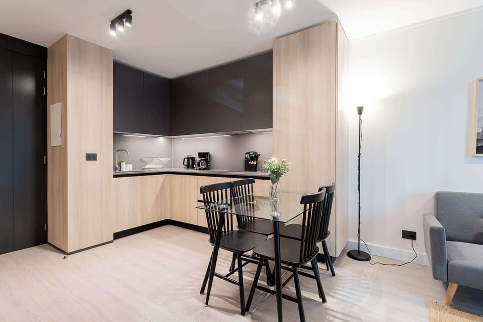 Experience modern living in this stylish kitchen, featuring sleek cabinetry and a cozy dining area perfect for meals and gatherings.