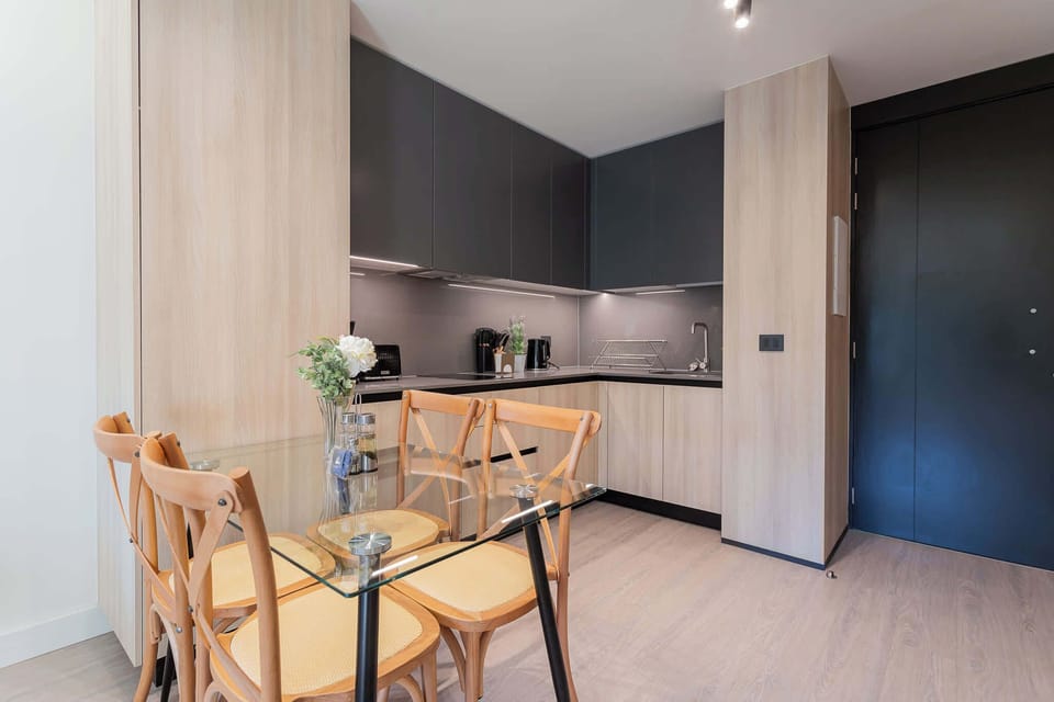 Modern kitchen with sleek cabinetry and a cozy dining area, perfect for enjoying meals together.