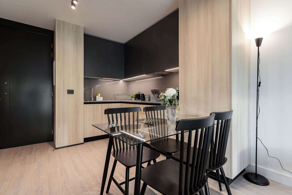 Experience modern living in this stylish kitchen, featuring sleek cabinetry and a cozy dining area perfect for meals and gatherings.