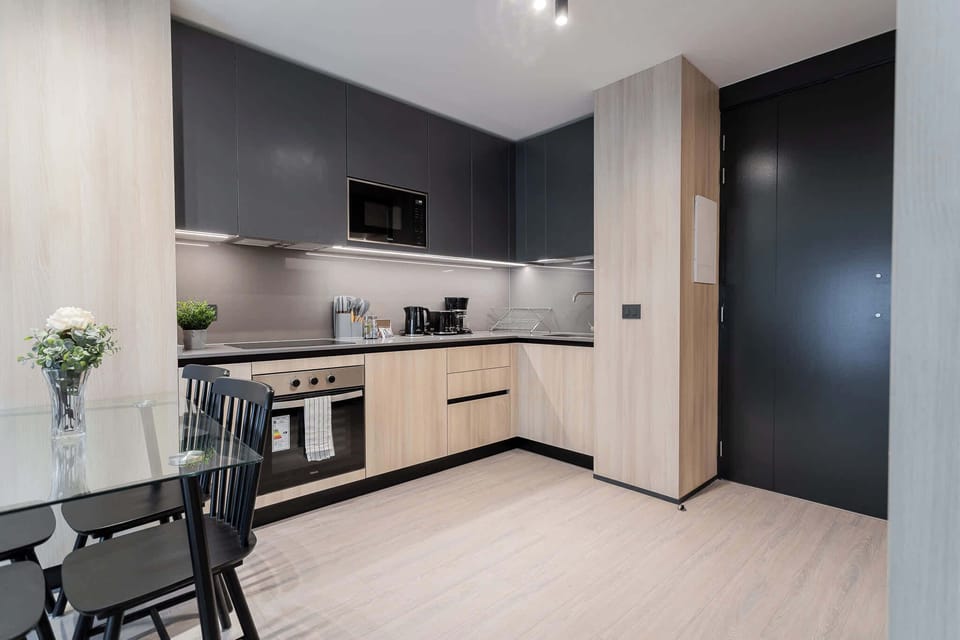 Experience modern living in this sleek kitchen, featuring high-end appliances and a chic dining area perfect for meals and gatherings.
