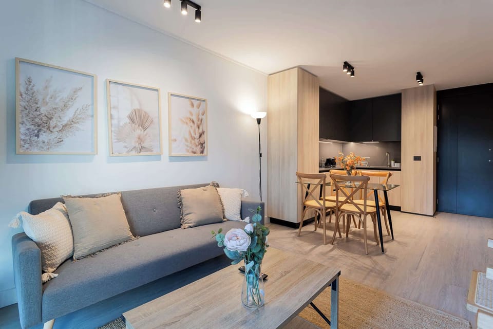 Experience modern comfort in this stylish living area, featuring cozy furnishings and a well-equipped kitchen for a perfect getaway.