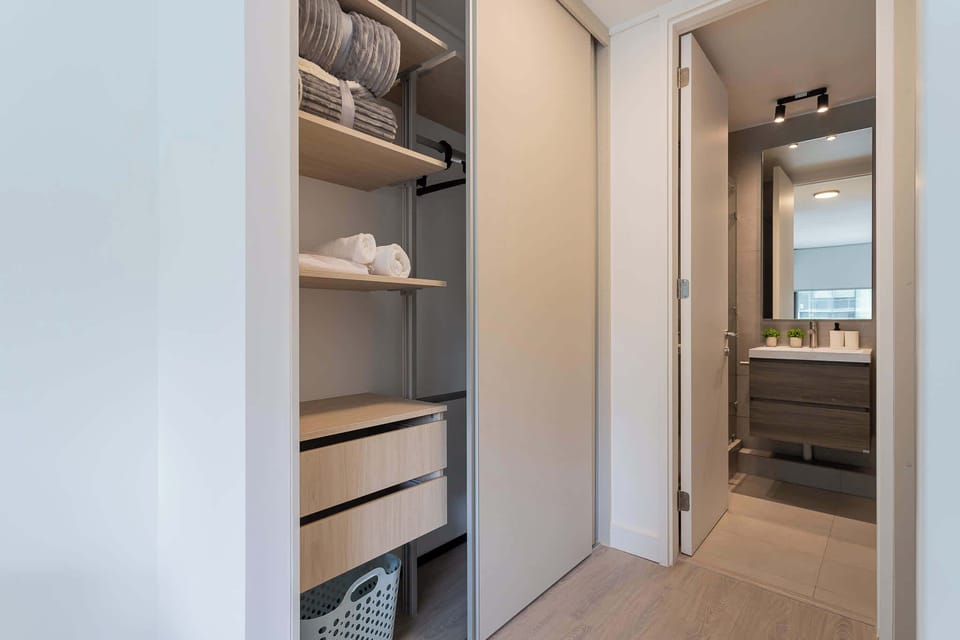Discover a modern bathroom with ample storage and a sleek design, perfect for a refreshing stay.