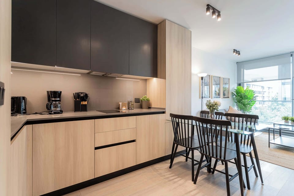 Experience modern living in this stylish kitchen, featuring sleek cabinetry and a bright dining area perfect for gatherings.