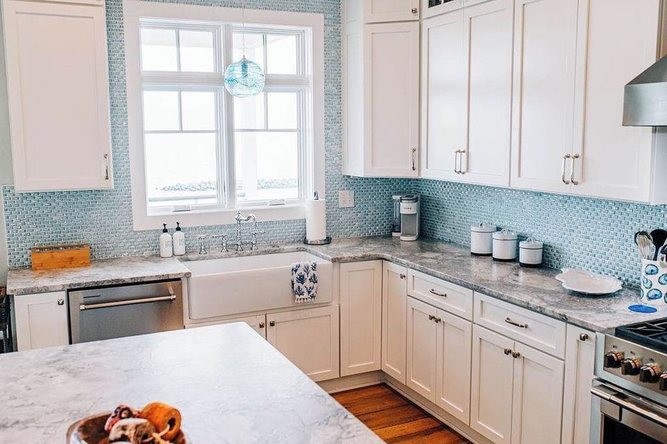 The heart of the home, where coastal light streams through windows framing the Bay. A chef’s kitchen designed for conversation, creativity, and comfort.