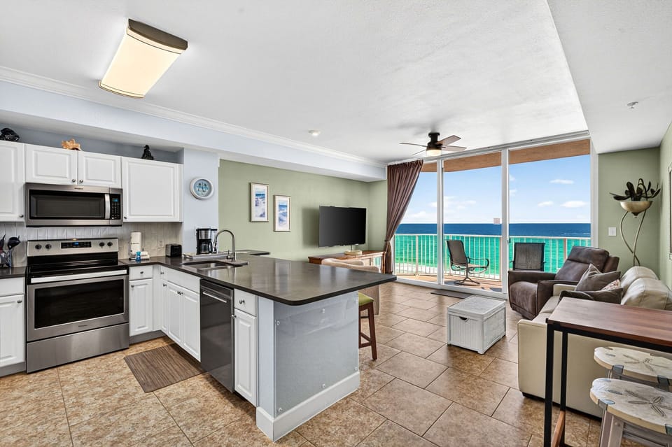 Open-concept kitchen and living area with ocean views and balcony access