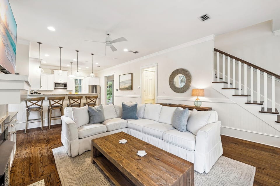 Unwind in your spacious living area where coastal elegance meets comfort, featuring plush seating and an open layout perfect for gathering.