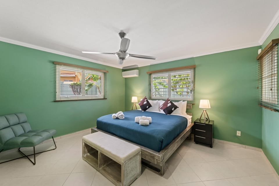 Spacious primary bedroom with King sized comfy bed and large windows that fill the room with natural light – your quiet place to recharge after a day in the sun.