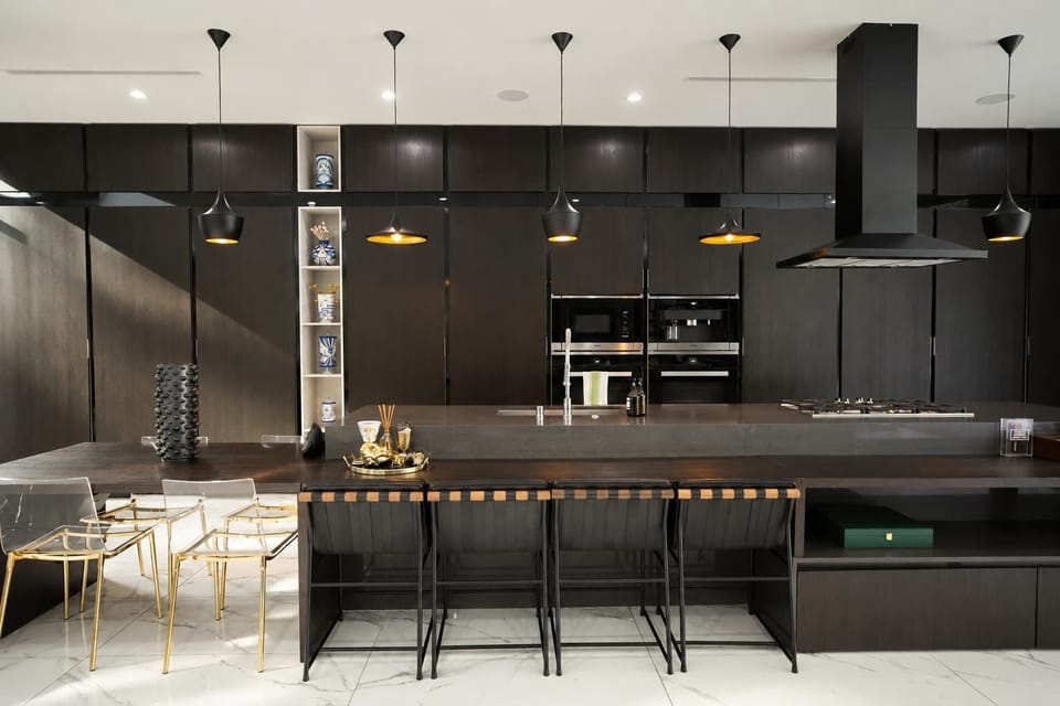 Chef's kitchen with dual Miele ovens, a gas cooktop, and an oversized island that seats four.