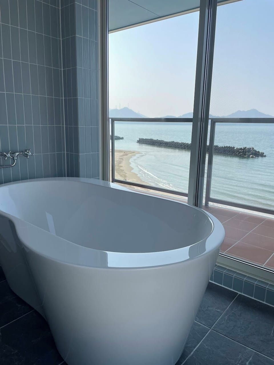 Separate tub and shower, hair dryer, slippers, towels