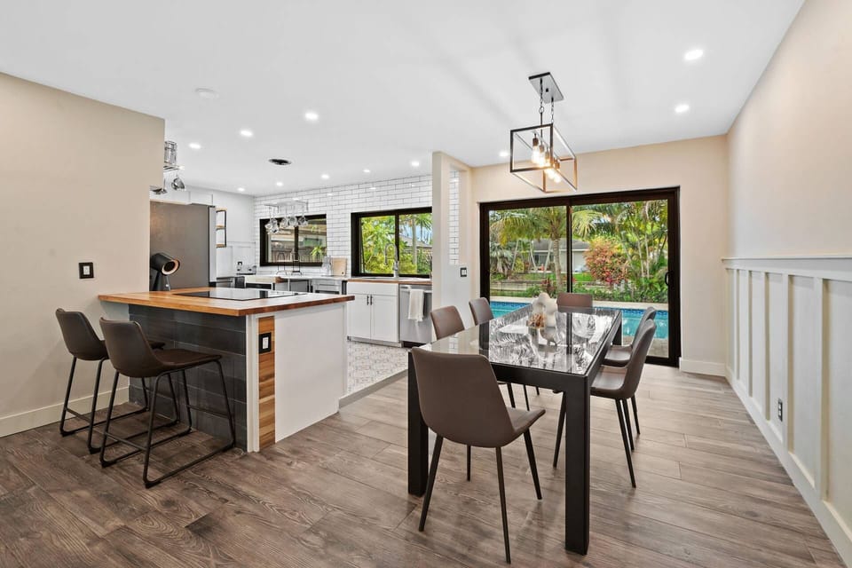 Dining for up to eight beside the renovated kitchen, with island seating and a private pool view