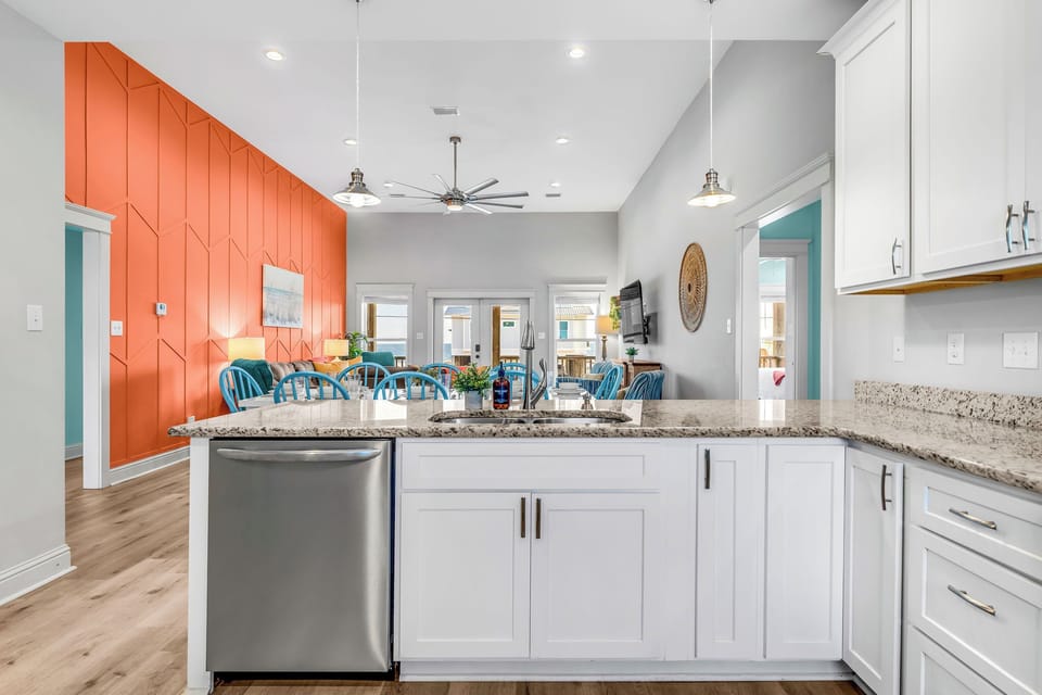 Spacious open kitchen w/ stainless steel appliances, well stocked to make meals.
