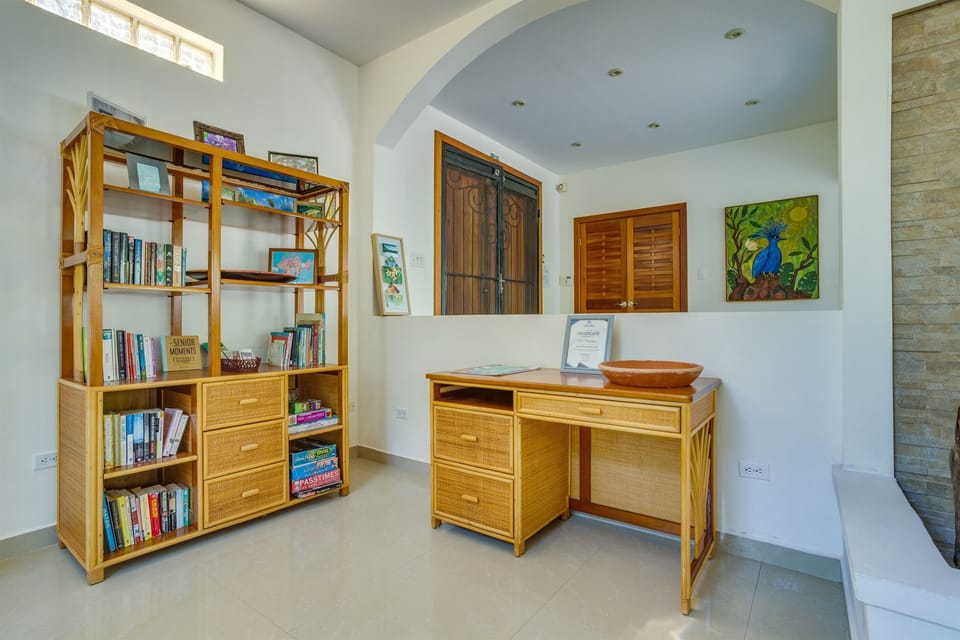 Office desk and bookshelf with books and games