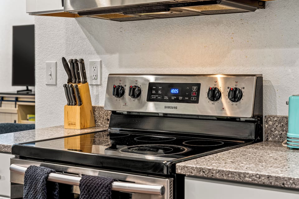 - Sleek Samsung stove with smooth top burners ready for your favorite meals
- Full knife set and countertop space make cooking easy and convenient
- Tucked under bright lighting, this cozy kitchen corner is chef ready

