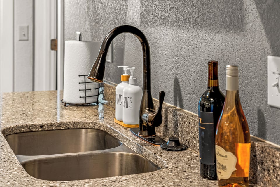 - Stylish kitchen sink setup featuring wine, hand soap, and modern faucet
- Thoughtful details like bottle display and towel holder elevate the vibe
- Perfect spot to rinse, prep, and unwind with a glass of something special