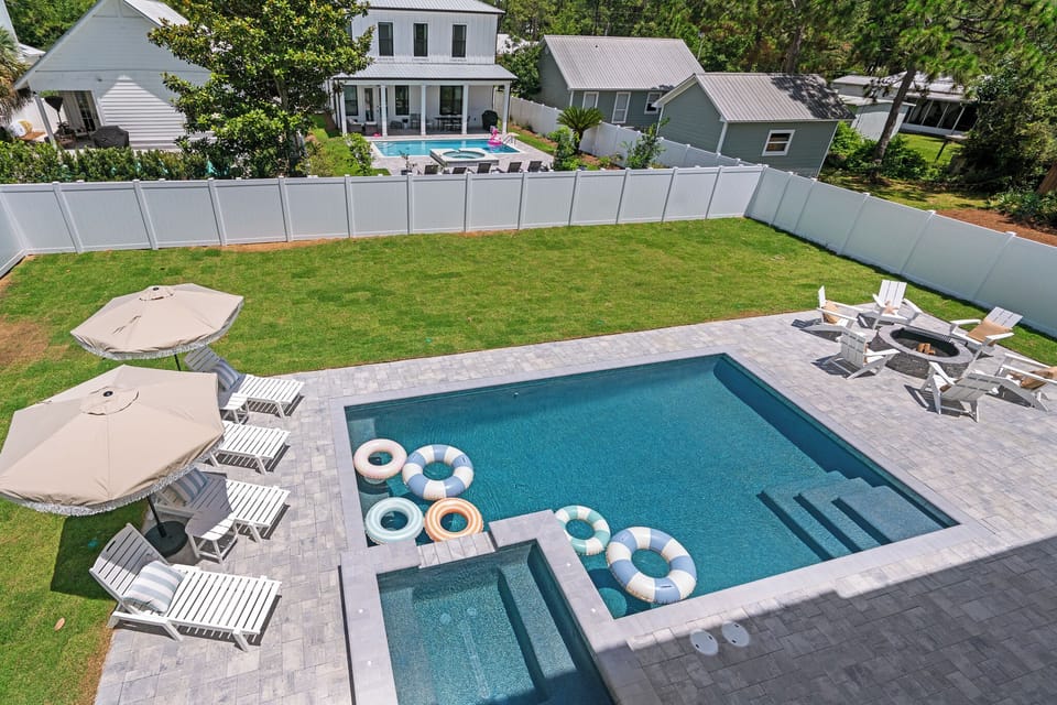 Backyard oasis with pool, hot tub, fire pit, loungers & putting green