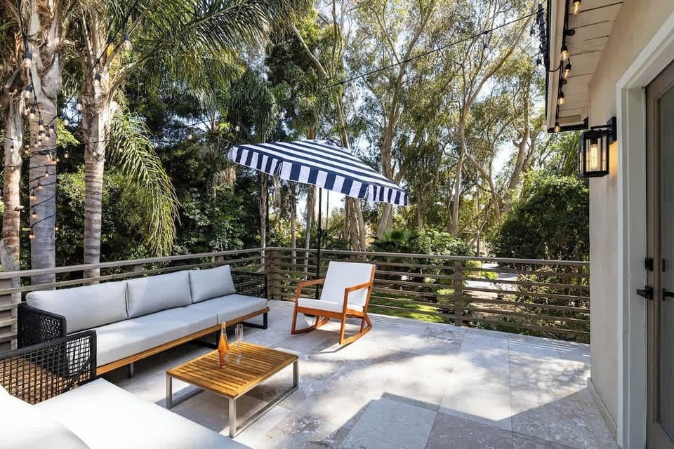 Enjoy a glass of wine on this stunning balcony overlooking the park-like front yard, surrounded by eucalyptus and palm trees.
