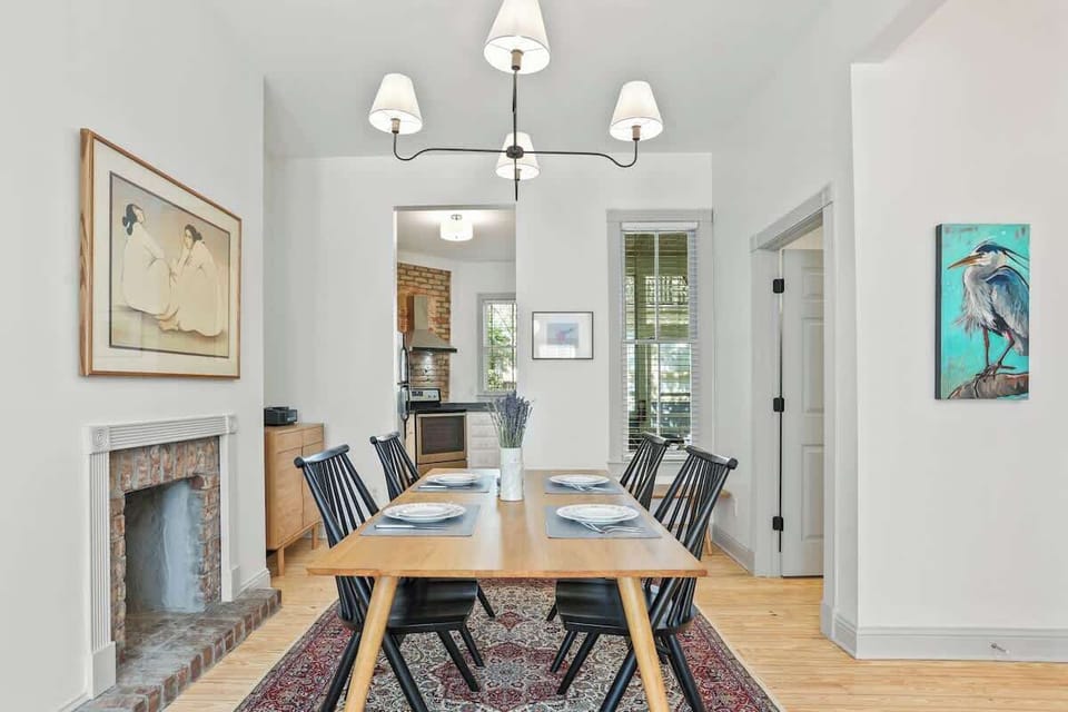 Lined with colorful modern art pieces, this dining room is the perfect space to gather with friends or family. 