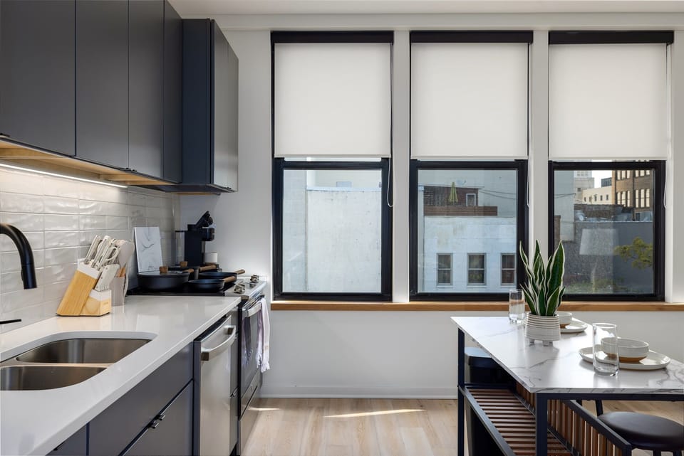 Fully stocked—this kitchen is ready for your culinary creations, with high-quality utensils, cookware, and a view of the city that adds inspiration to your meal prep