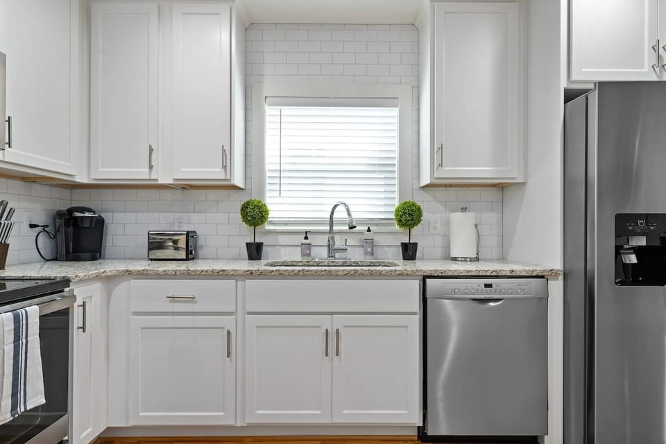 The kitchen workspace is both functional and picturesque, making meal prep enjoyable with a glimpse of the outdoors.