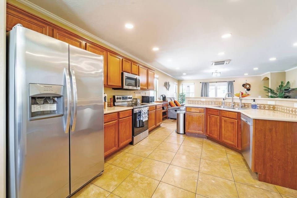 Spacious, well-lit kitchen with stainless appliances and breakfast bar