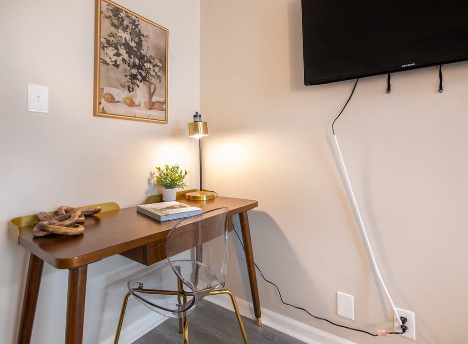 Another angle of the compact workspace with mid-century modern desk and mounted TV — a great remote work setup.