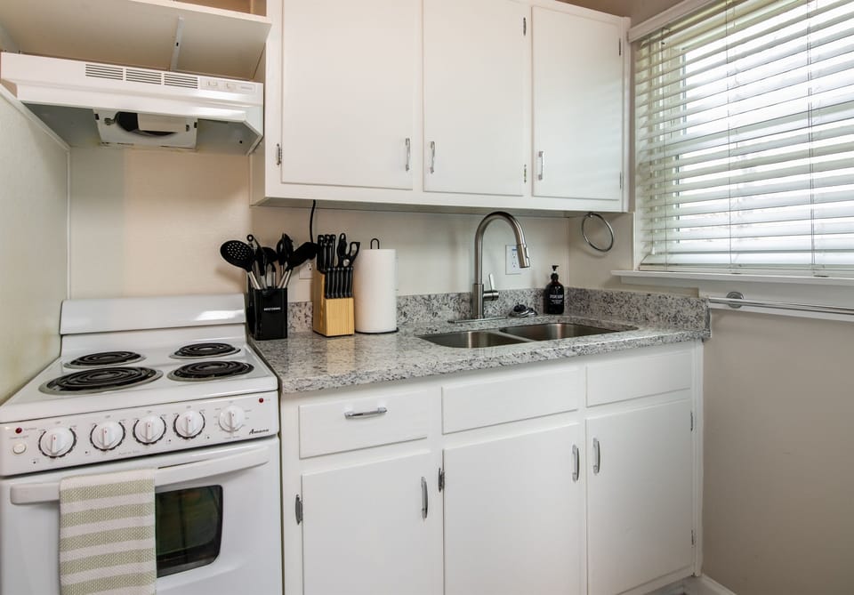 Clean and efficient kitchen layout featuring a stovetop, oven, microwave, and plenty of counter space.