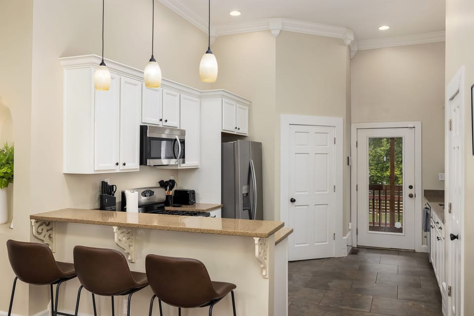 Kitchen featuring sleek bar stools, perfect for casual dining and socializing. Reach out to us for our personalized concierge services and handpicked local experiences. 