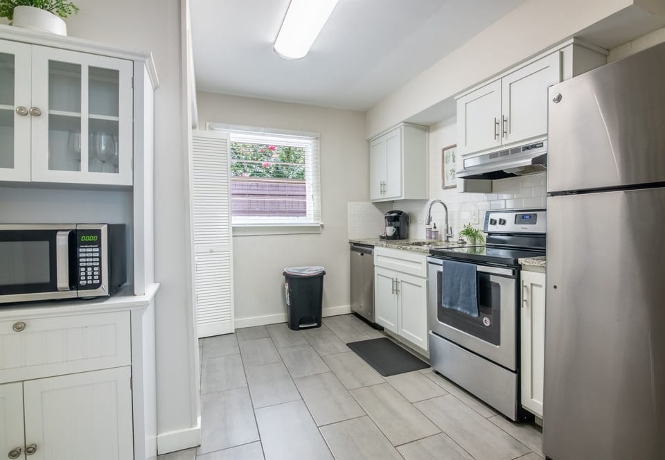 Functional galley kitchen with ample cabinetry, stainless appliances, and essentials for cooking.