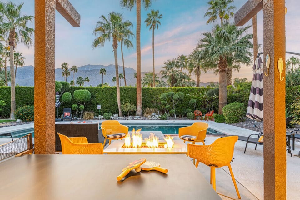 Outdoor firepit seating framed by palms, perfect for evening chats under the desert sky.
