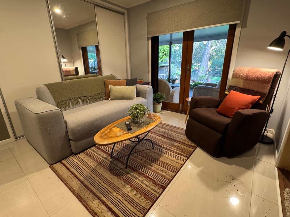 Lounge room, air con with 3 seater Koala sofa, single lounge chair and 65 inch smart TV.