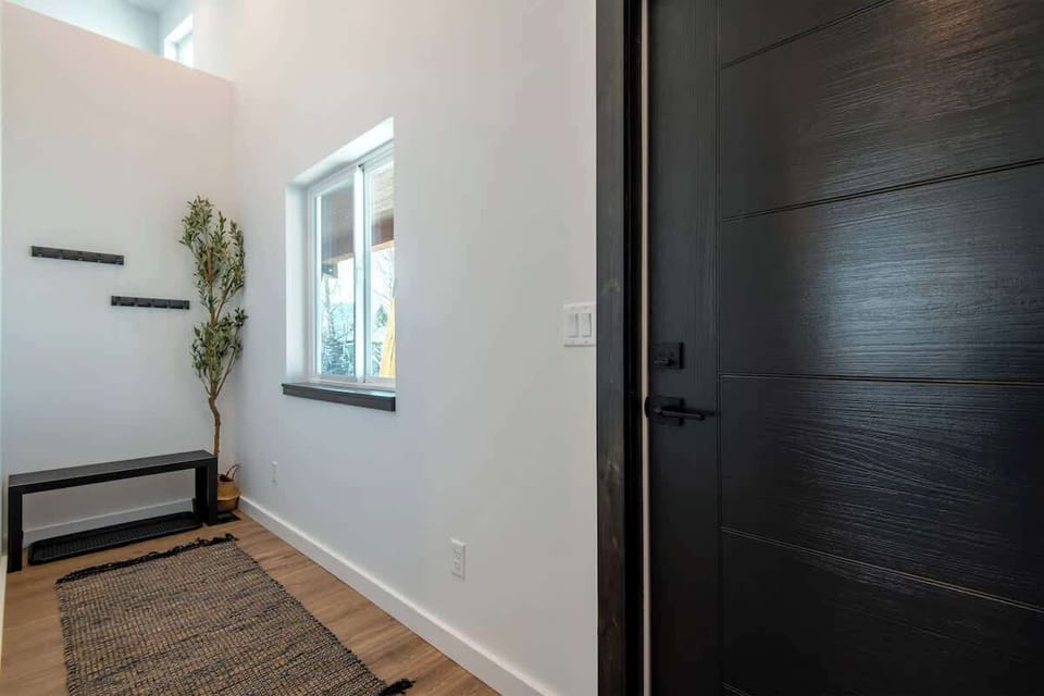 The front entry welcomes you with functionality and charm. Designed for convenience, it features a dedicated space to hang your coats and a comfortable area to take off your shoes.