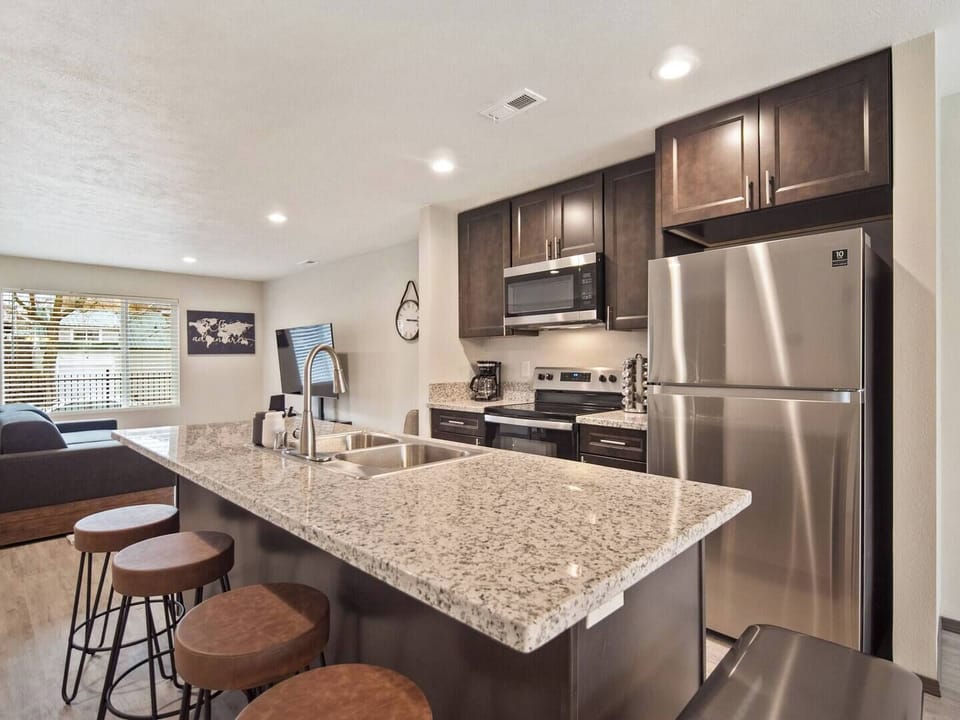 Full kitchen with sink in-island and bar seating. 