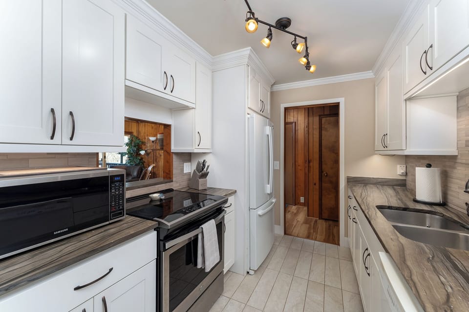 The updated kitchen boasts stainless steel appliances, a dishwasher, and a Keurig coffeemaker.