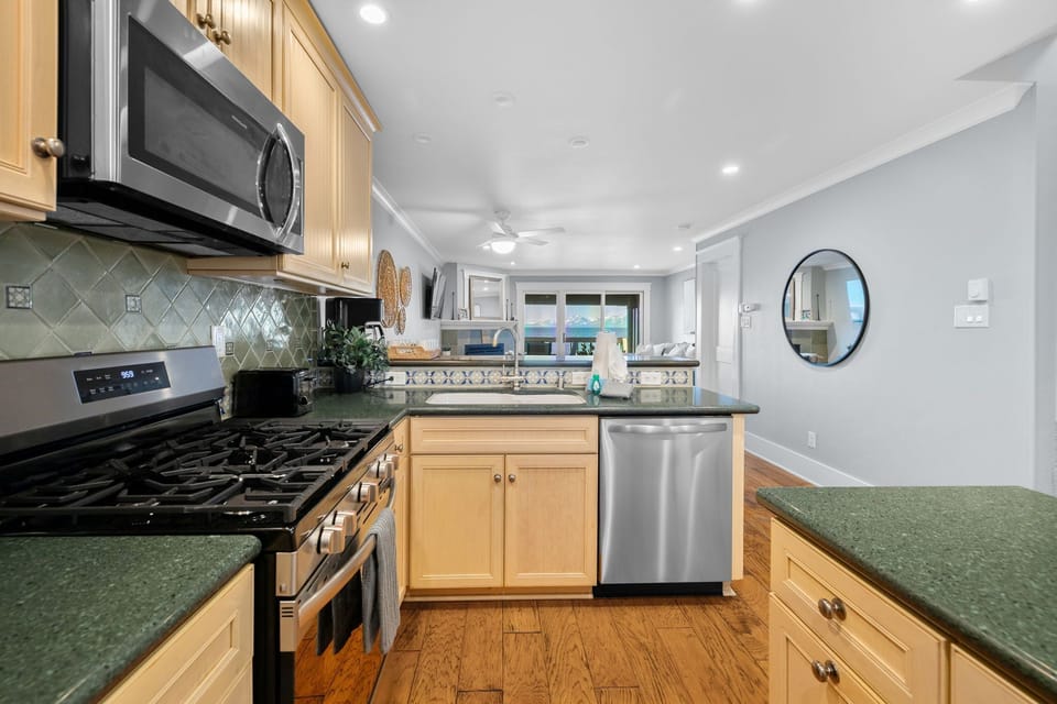 Updated kitchen features eye-catching green granite countertops, stainless steel appliances, and all the essentials to make meal prep a breeze.