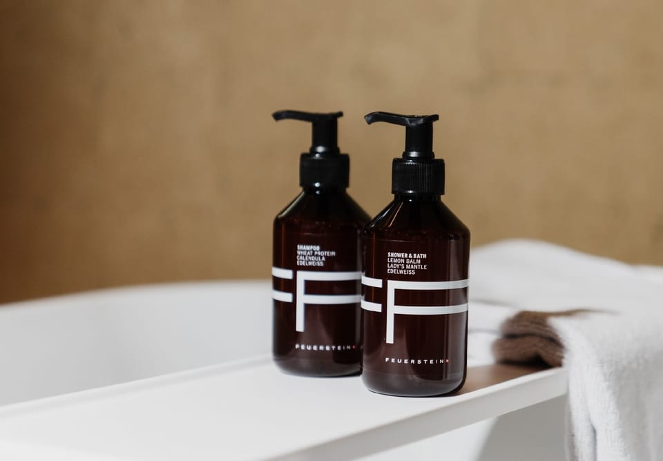 Designer toiletries, hair dryer, slippers, towels